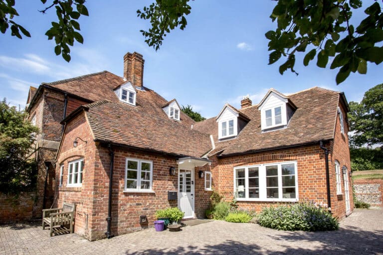 isted heritage house with red clay tile roof and oak-framed extension, showing traditional building methods integrated with historic property renovation