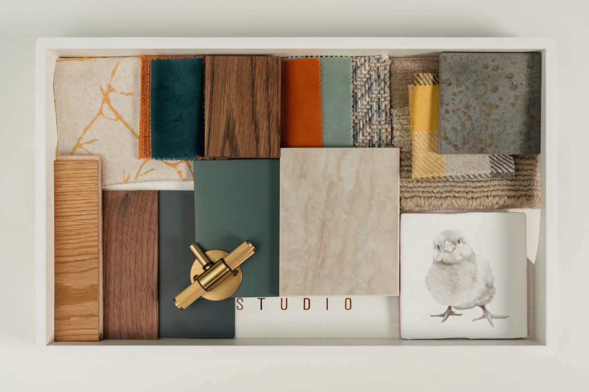 Curated material palette by one of the best interior designers in Essex featuring fabric swatches, wood samples, brass hardware, and natural stone